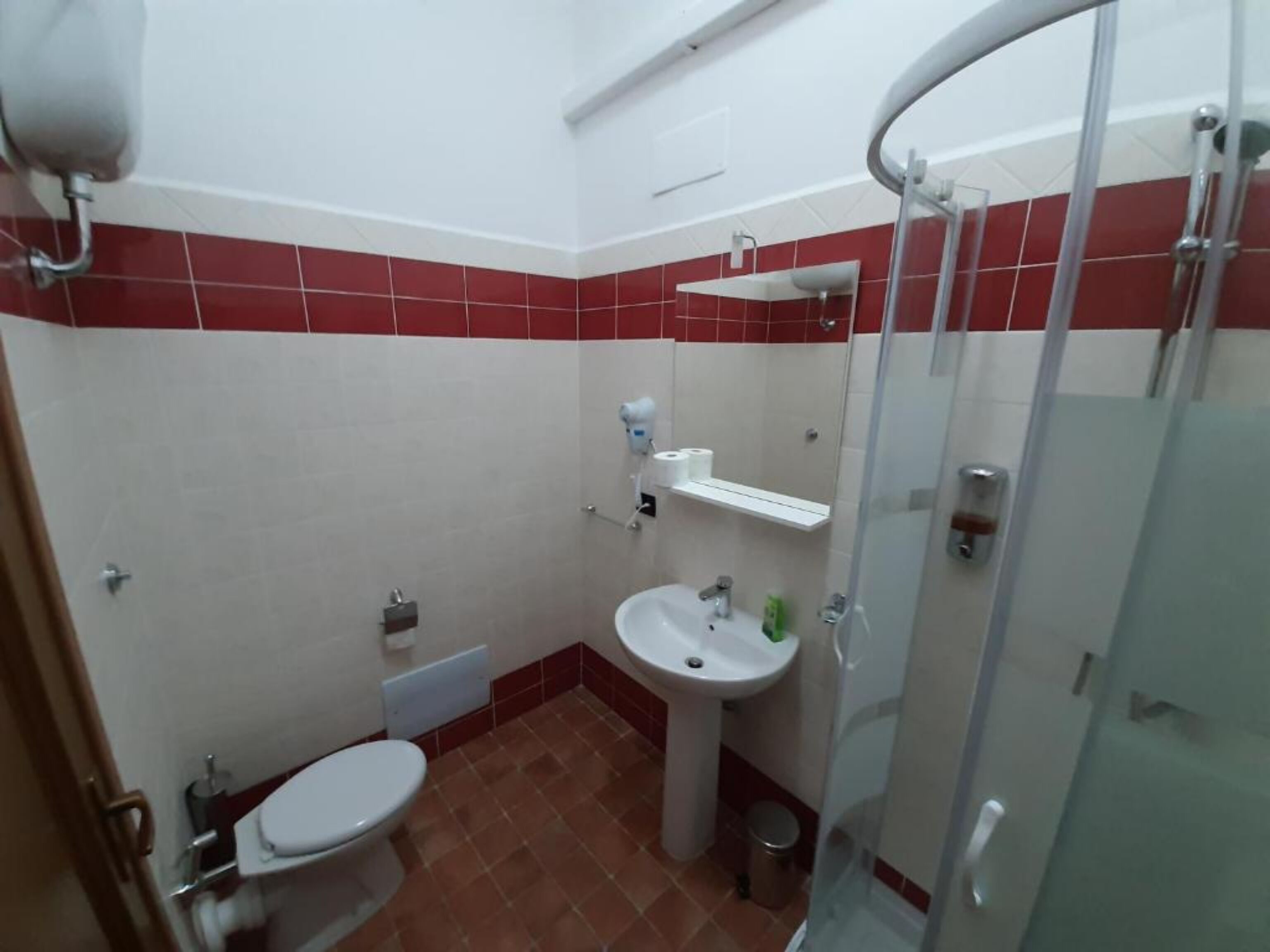 A bathroom with a toilet, sink, and shower.