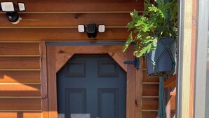 A wooden door with a black glass panel and a cross-shaped gate. - Secluded Off-Grid Cabin, Upper Peninsula Getaway on 36 Private Acres (Bruce Crossing)