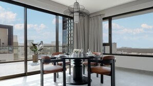 A modern dining area with a round table, chairs, and a chandelier. - Fraser Suites AL Liwan (Hamala)