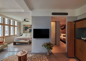 A modern hotel room with a large bed, a flat-screen TV mounted on the wall, a wooden wardrobe, and a large window offering a view of the city. - 21 Carpenter, Singapore, a Member of Design Hotels (Singapore)