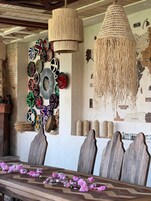Un comedor con una mesa de madera, sillas y una pared decorada con platos de distintos diseños.