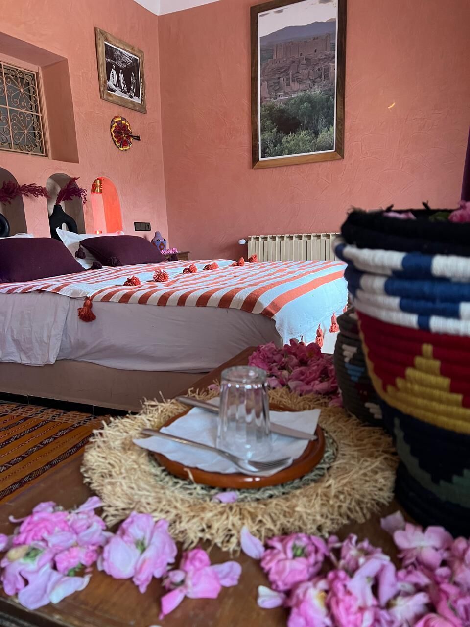 Una habitación de hotel con una cama, un ventanal grande, un radiador y un adorno en la pared.