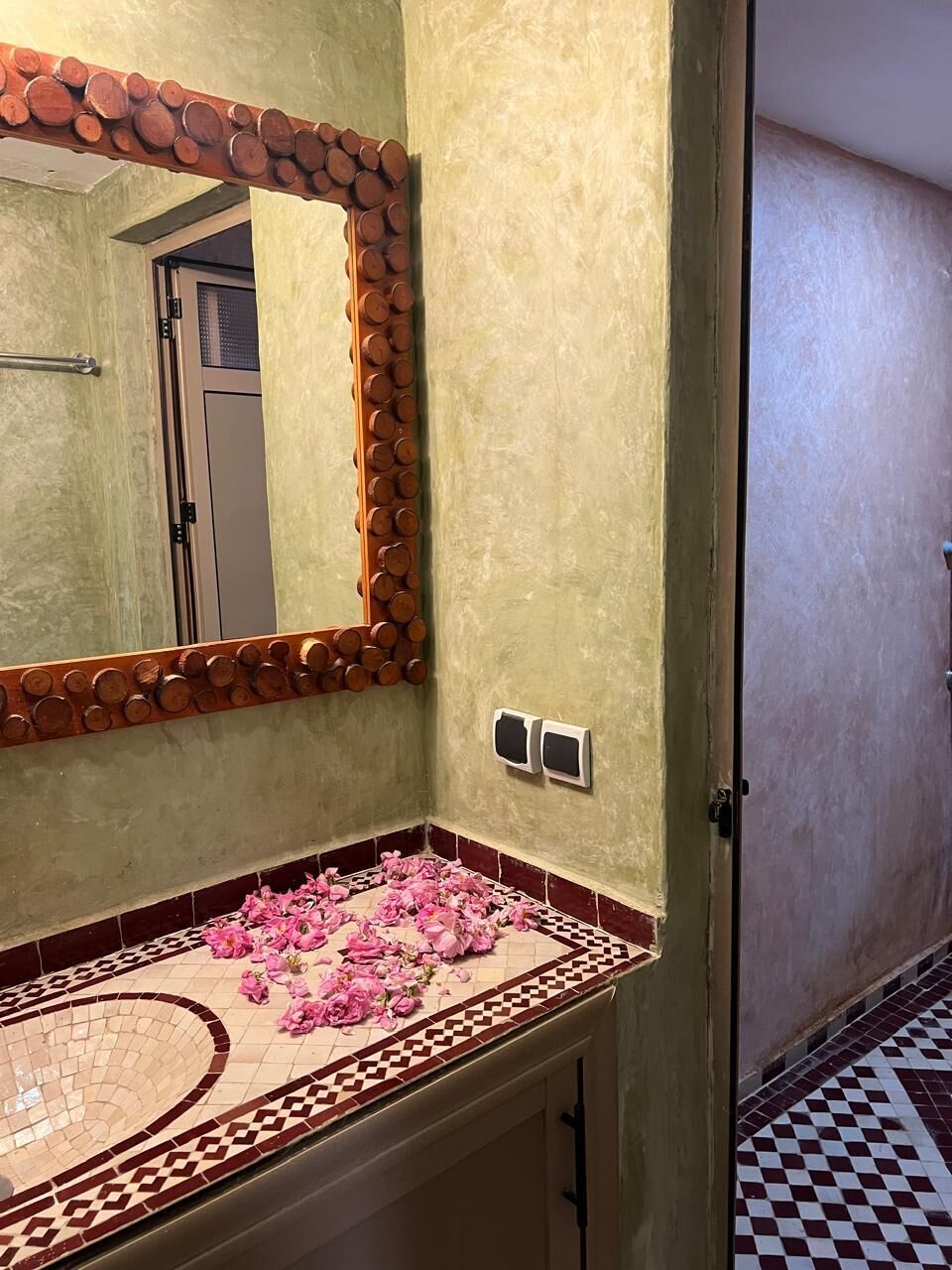 Ein Badezimmer mit Spiegel, Waschbecken und Fliesenboden.