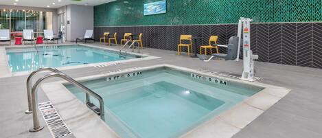A swimming pool with a 3 FT 0 0 M depth marker, surrounded by lounge chairs and a fitness machine.