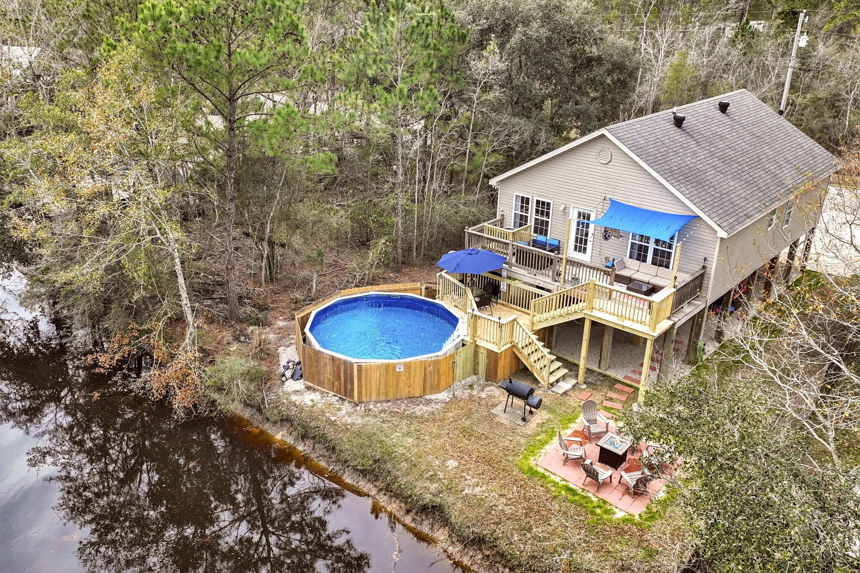 A house with a deck, a hot tub, and a pool.