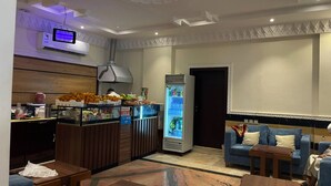 A hotel lobby with a seating area, a refreshment bar, and a refrigerator.
