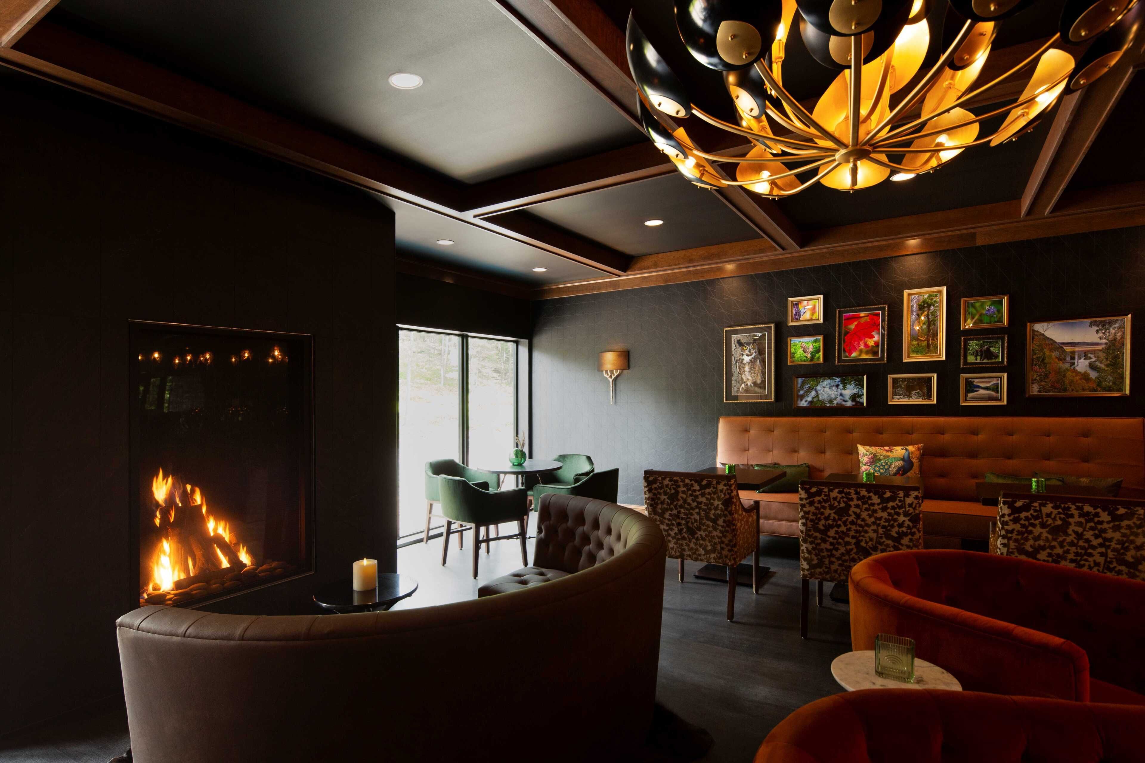 A modern lounge with a fireplace, comfortable seating, and artwork on the walls.