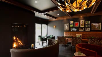 A modern lounge with a fireplace, comfortable seating, and artwork on the walls.