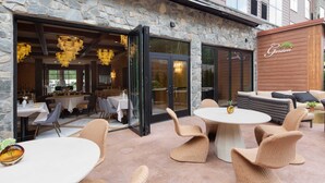 An outdoor seating area with wicker furniture and a stone facade.