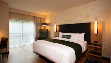 Una habitación de hotel moderna con una cama grande, un escritorio y una silla.