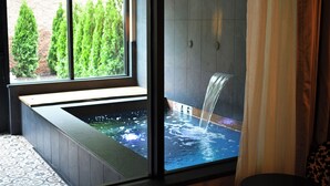 A modern bathroom with a large window, a bathtub, and a shower area.