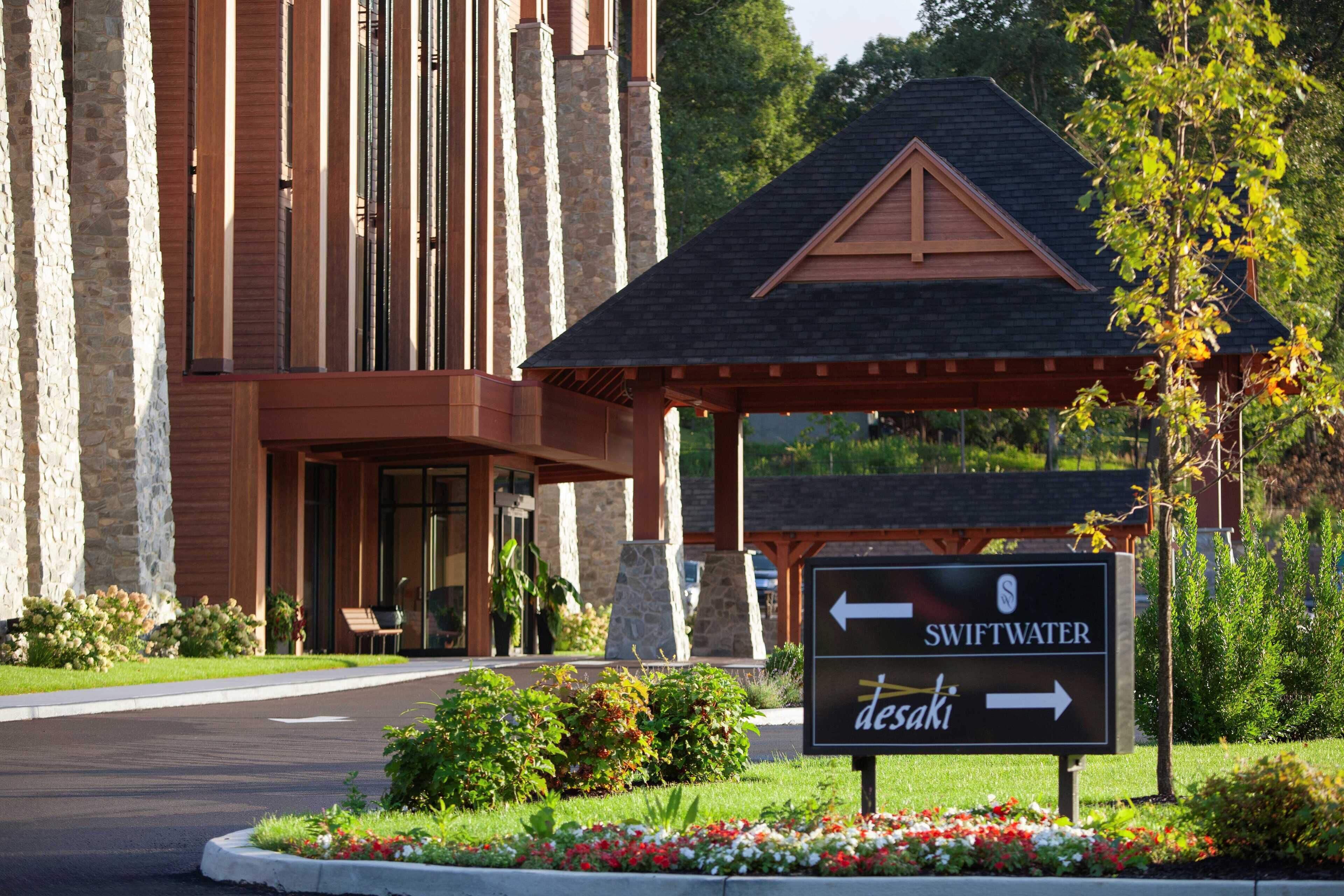 L’entrée d’un hôtel, avec un panneau indiquant les directions vers Swiftwater et Desaki.