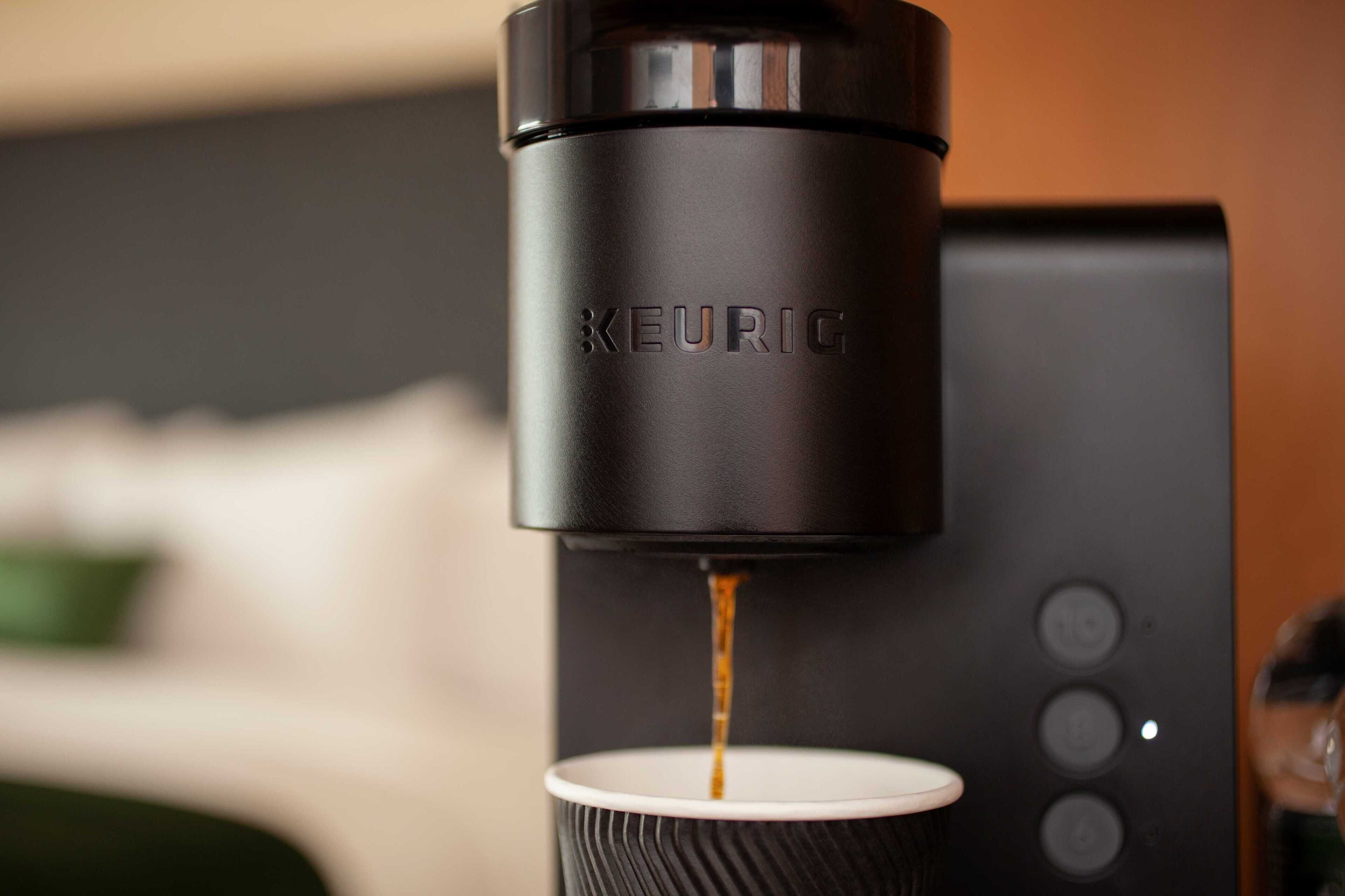 A Keurig coffee machine dispensing coffee into a cup.
