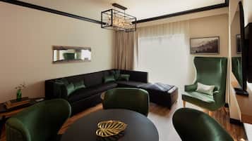 A modern living room with a sectional sofa, a round table with a decorative bowl, and a green armchair.