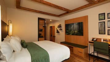 Um quarto com cama, escrivaninha, cadeira, quadro e teto de madeira.