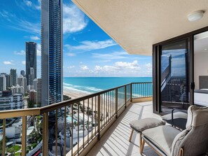 Un balcon avec vue sur la plage et le paysage urbain.