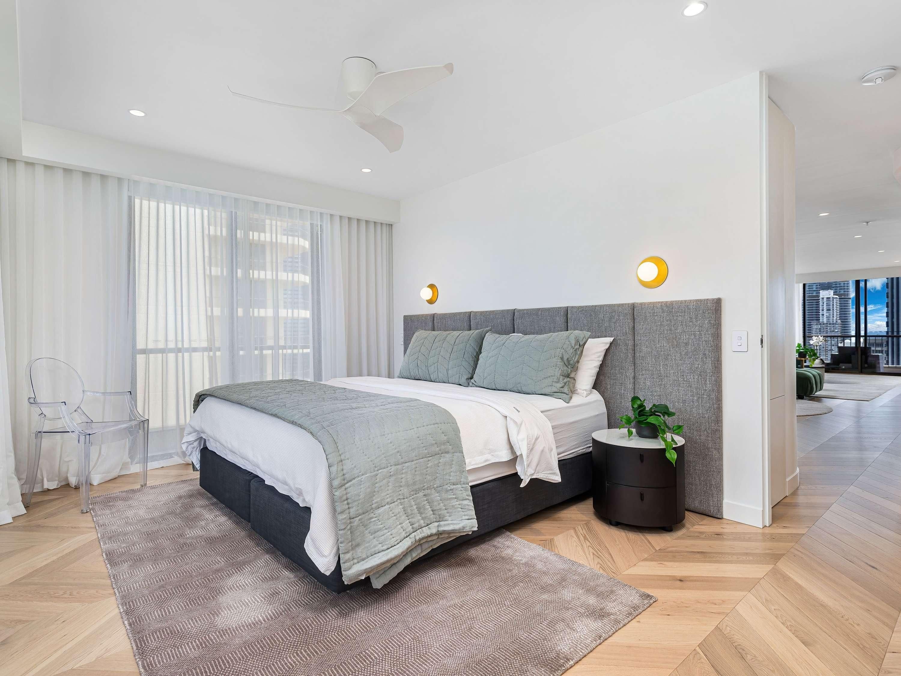 Un dormitorio moderno con cama, mesita de noche y vista a la ciudad.