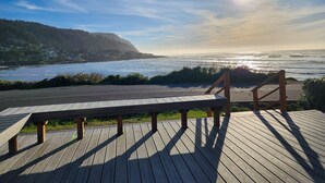 Una terrassa de fusta amb una banca davant d'una vista costanera.