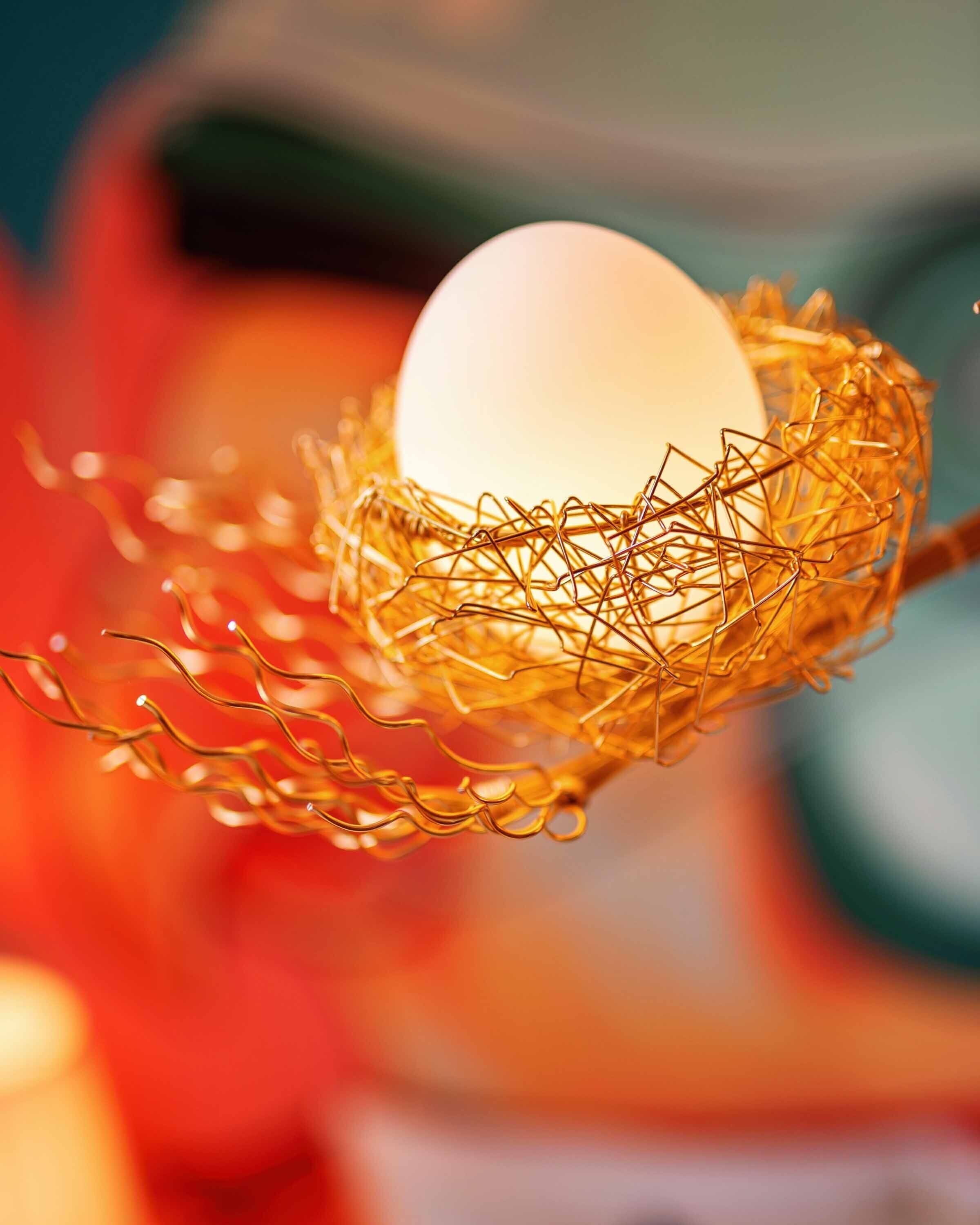 A close-up of a spherical object in a golden wire basket.