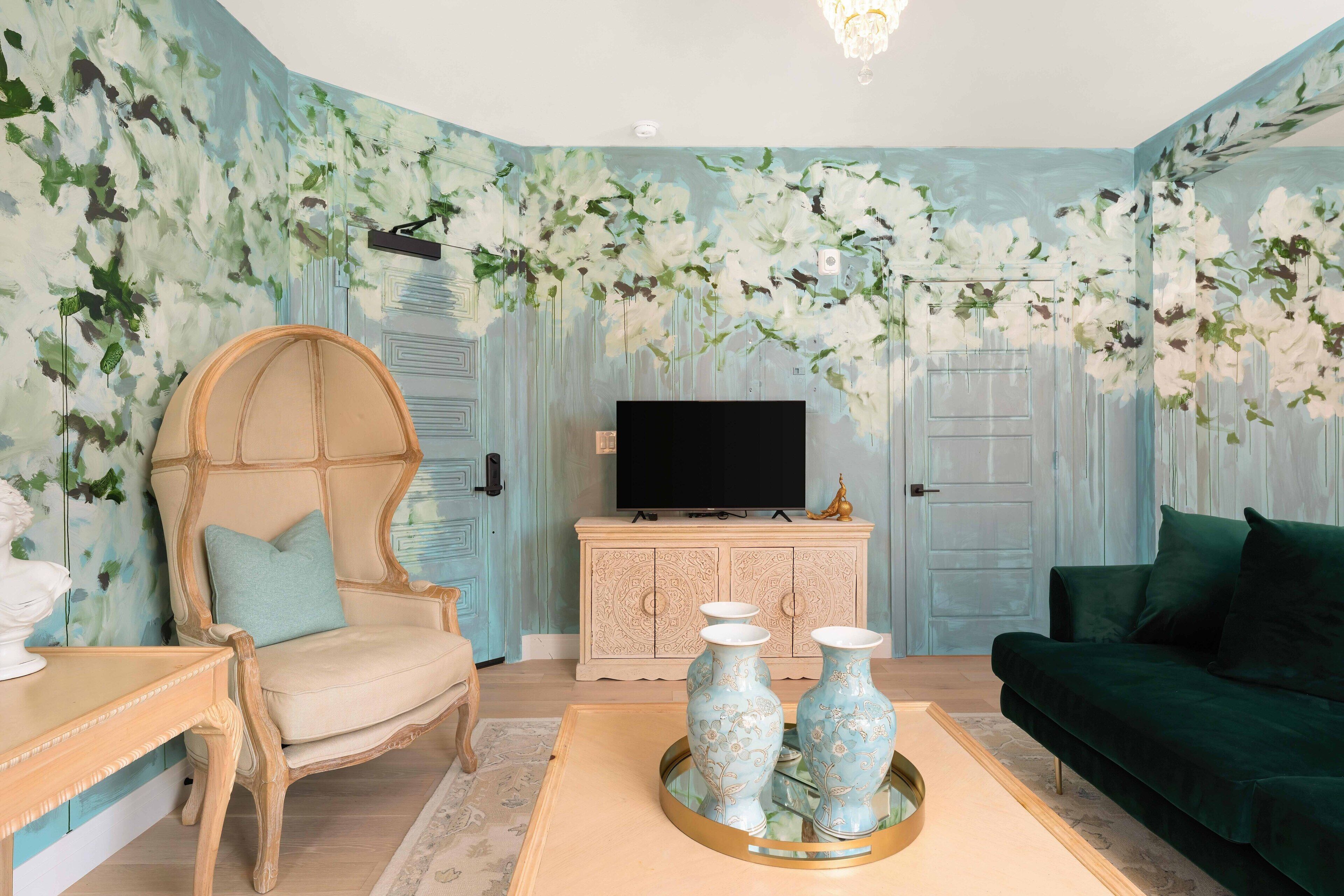 A living room with a large armchair, a sofa, a TV, and decorative vases on a coffee table.