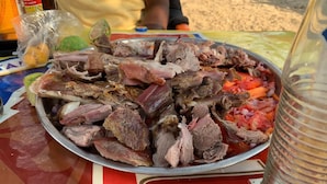 A metal tray filled with various cuts of meat and vegetables on a table. - Kinyaiya's Farm Lodge (Moshi)