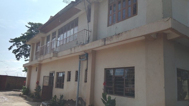 A two-story building with a balcony on the upper floor. - Kinyaiya's Farm Lodge (Moshi)