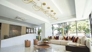 Una sala de estar moderna con un sofá modular, una mesa de centro y una lámpara decorativa en el techo.