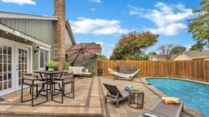 A backyard with a pool, patio furniture, a hammock, and a wooden fence. - Pool Playhouse: FirePit, Grill, Billiards & Jenga (Richardson)