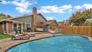 A backyard with a swimming pool, a barbecue area, and a wooden fence. - Pool Playhouse: FirePit, Grill, Billiards & Jenga (Richardson)