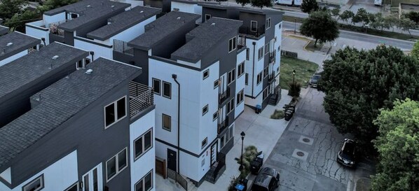 Un immeuble d’appartements moderne comprenant plusieurs logements, un espace de stationnement et donnant sur la rue.