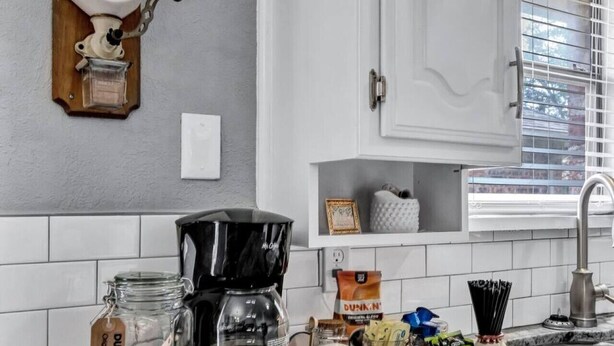 A kitchen with a coffee maker, a coffee grinder, a jar of Dunkin' coffee beans, and a coffee pot on the counter. - Pool PlayHouse: Firepit, Grill, Games & Sunlounger (Allen)