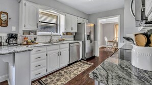 A modern kitchen with white cabinetry, a stainless steel refrigerator, and a coffee maker. - Pool PlayHouse: Firepit, Grill, Games & Sunlounger (Allen)