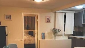 A compact living space with a dining area, kitchenette, and a bedroom. - Cozy Sunset suite (San Francisco)