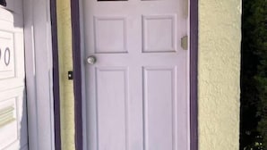 A white door with a purple frame and a small window above it. - Cozy Sunset suite (San Francisco)