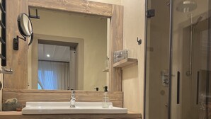 A bathroom with a wooden vanity, a glass shower enclosure, and a mirror with a wooden frame. - Unterkunft Nähe Magdeburg und Oschersleben Motorpark (Wanzleben-Börde)