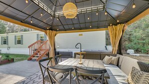 An outdoor patio with a dining table, chairs, and a sofa.