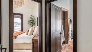 Ein Schlafzimmer mit einem Bett, einer Topfpflanze und Blick ins Freie.