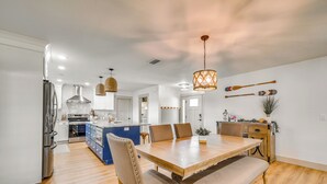 Une cuisine moderne dotée d’un îlot central, d’une table à manger en bois et de bancs.