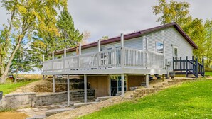 A two-story house with a balcony, stone steps, and a wooden fence.