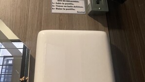 A sign with instructions for using a restroom, a power outlet, and a wall-mounted electrical box.