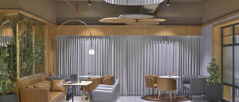 Un intérieur moderne avec un canapé, des fauteuils, une table et des plantes en pot.