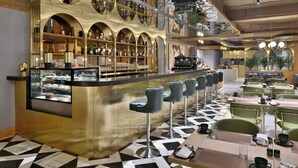 Un espace bar comprenant un comptoir, des tabourets et une vitrine.