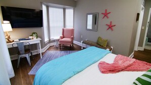 A bedroom with a bed, desk, chair, and a TV. - The Capitol Inn - Destin Room - Queen bed (Tallahassee)