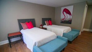 A bedroom with two beds, a nightstand, and a bench. - The Capitol Inn - Orlando Room - 2 Twin beds (Tallahassee)
