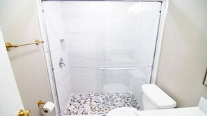 A small bathroom with a shower, toilet, and sink. - The Capitol Inn - Orlando Room - 2 Twin beds (Tallahassee)