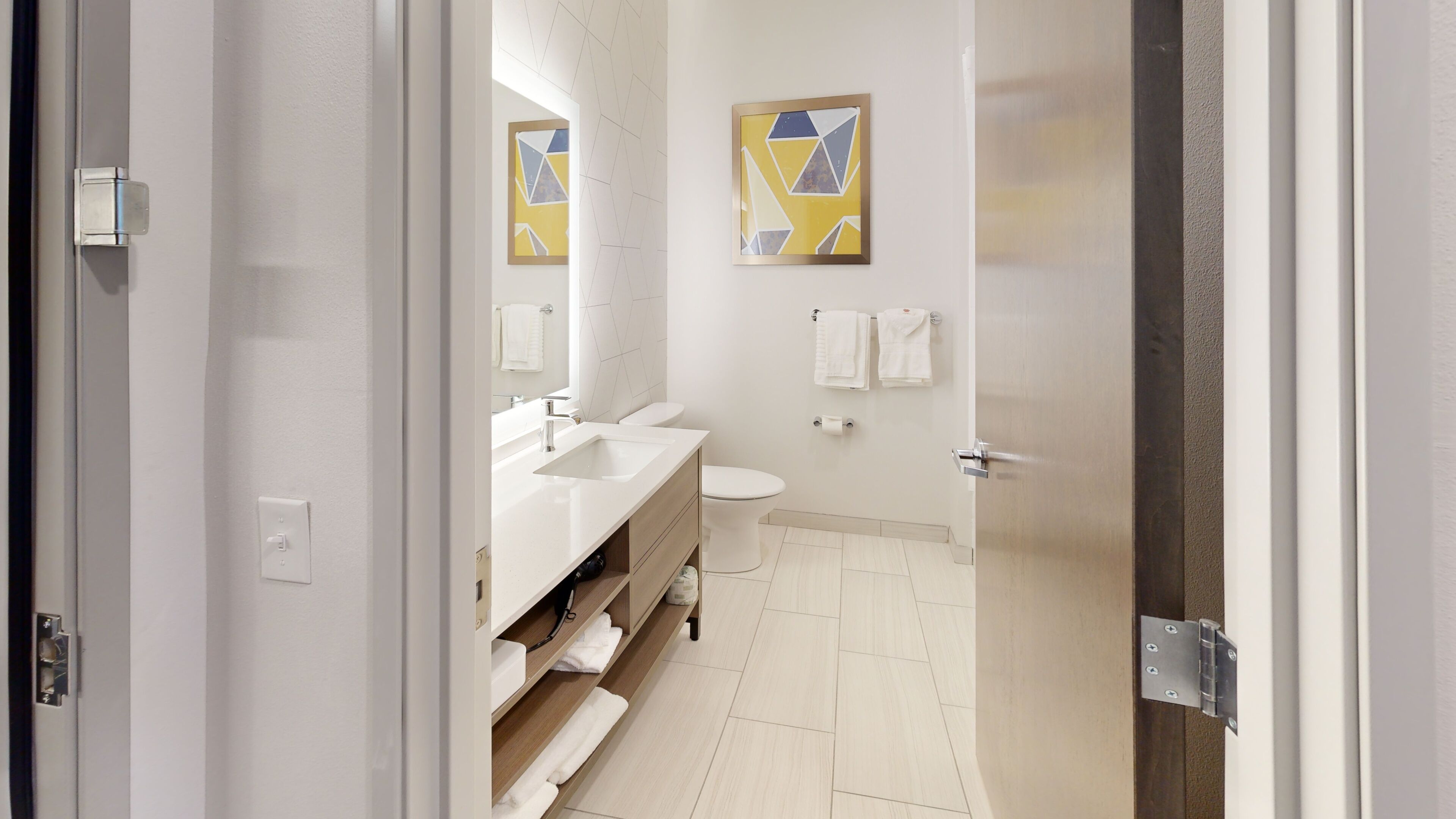 A modern bathroom with a sink, toilet, and towel rack.