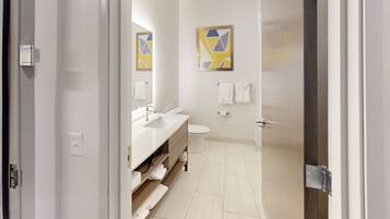 A modern bathroom with a sink, toilet, and towel rack.