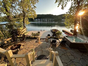 Terraza junto al lago con asientos al aire libre, una bañera de hidromasaje y vistas al lago.