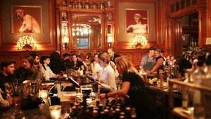 Un bar animé, décoré de bois, avec des œuvres d’art encadrées accrochées aux murs.