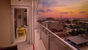 Ein Balkon mit Blick auf einen Sonnenuntergang über einer Stadtansicht.